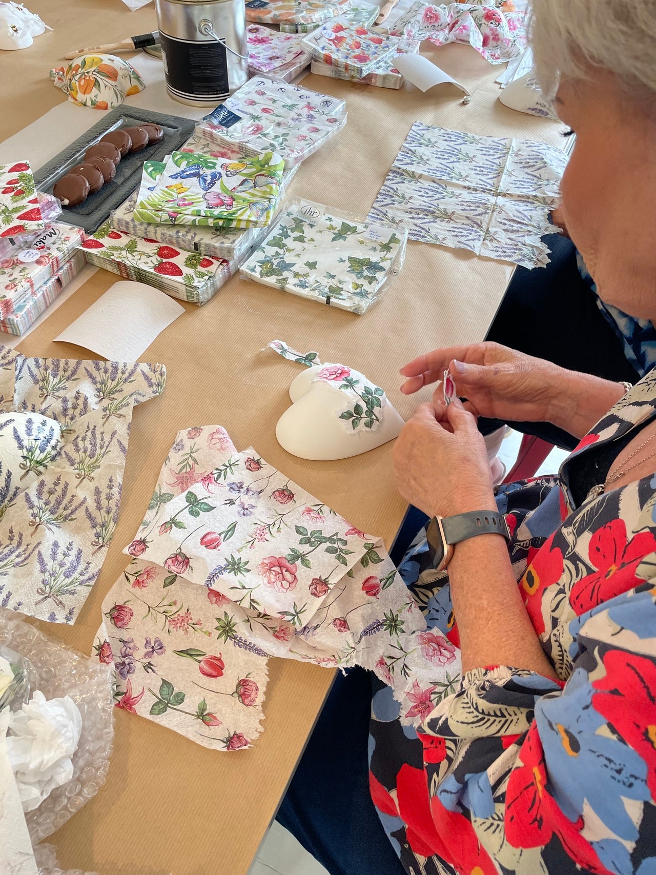 Person working with floral decoupage in a workshop
