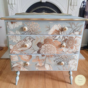 Set of Drawers painted in the French Chateau methode with Bach Blue chalk paint and the front is decoupaged with Foil Birds decoupage paper, a floral and bird design in gold and brown on a blue background.