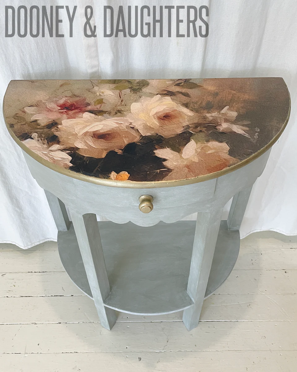 Floral-patterned table with rubbed sage base, and Romantic Roses decoupage paper on the top, decoupage paper featuring a printed image of roses in a blue vase, designed for use in furniture art and refurbishment.