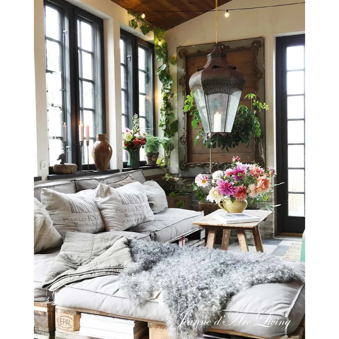 Cozy living room with a sofa, decorative pillows, and a hanging lantern.