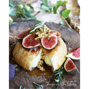 Baked brie with figs and nuts on a wooden board
